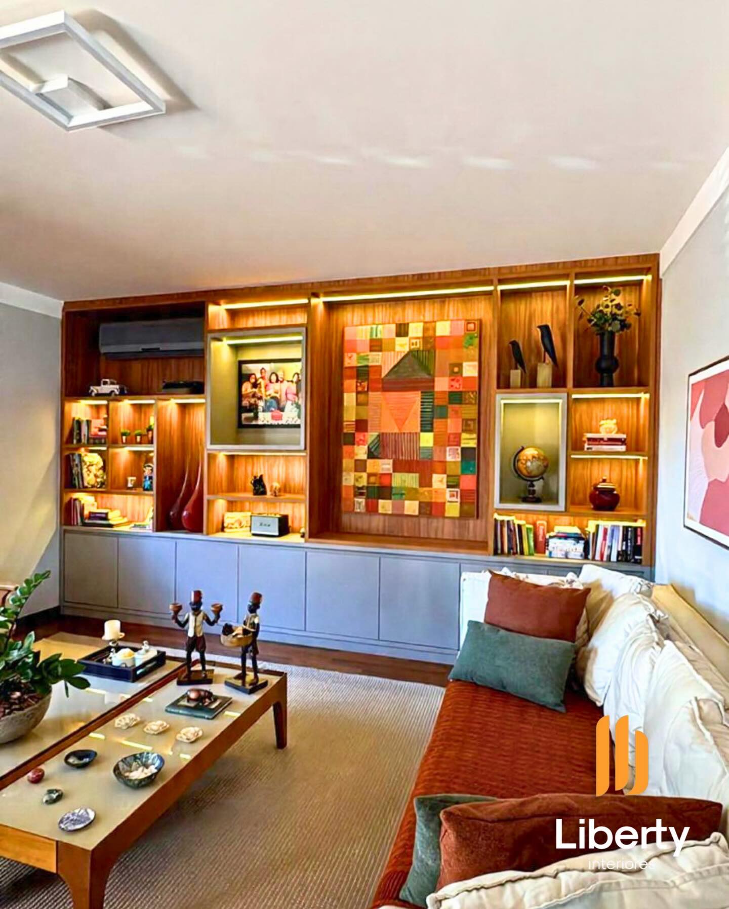 Sala com estante sob medida e iluminação valorizando o ambiente